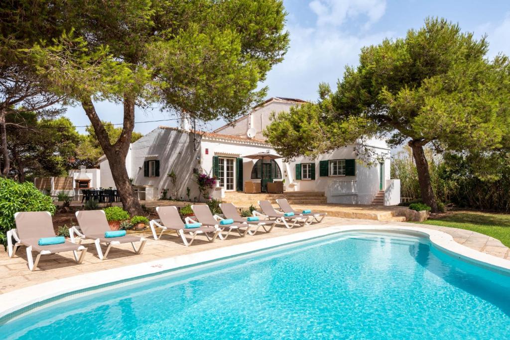 - une piscine avec des chaises et une maison dans l'établissement Hort d'es Milord - Es Castell, à Es Castell