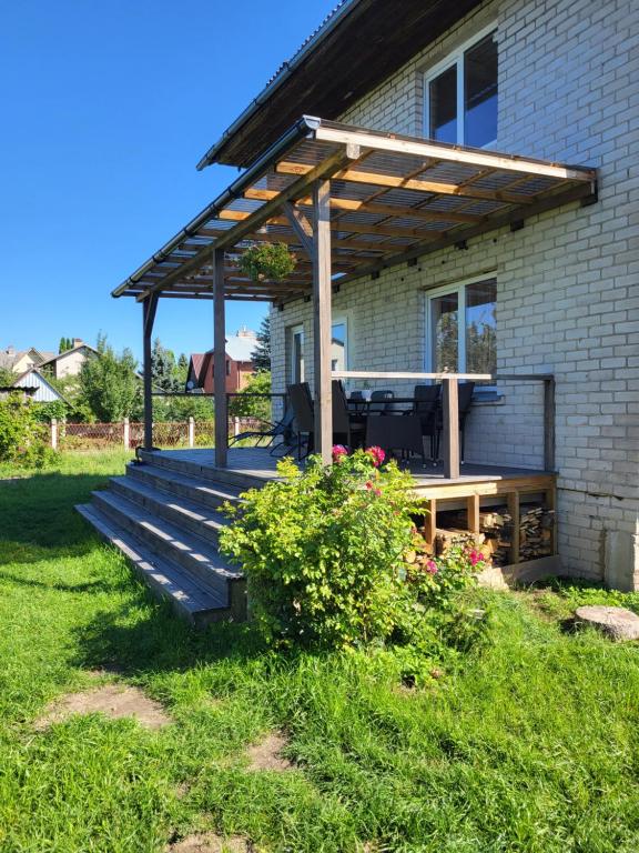 a deck with a pergola on the side of a house at Balsių namelis in Vilnius