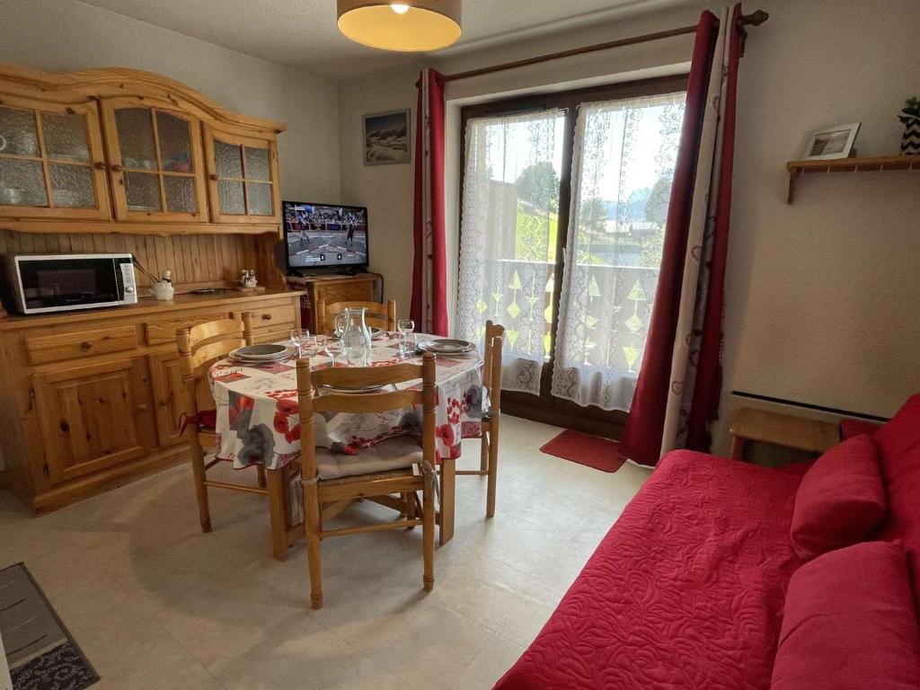 a living room with a table and chairs and a kitchen at Appartement Praz-sur-Arly, 2 pièces, 4 personnes - FR-1-603-39 in Praz-sur-Arly