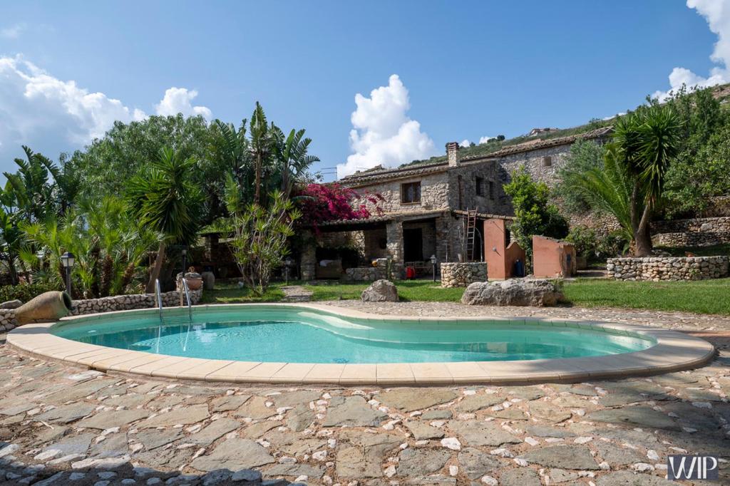 una piscina frente a una casa en Villa Audino, en Scopello