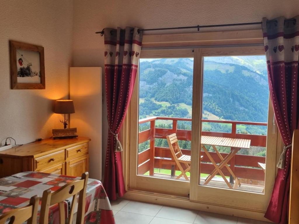 - une chambre avec une fenêtre offrant une vue sur la montagne dans l'établissement Appartement duplex familial 6 pers. à Crest-Voland avec balcon et à 50m des pistes - FR-1-733-67, à Crest-Voland