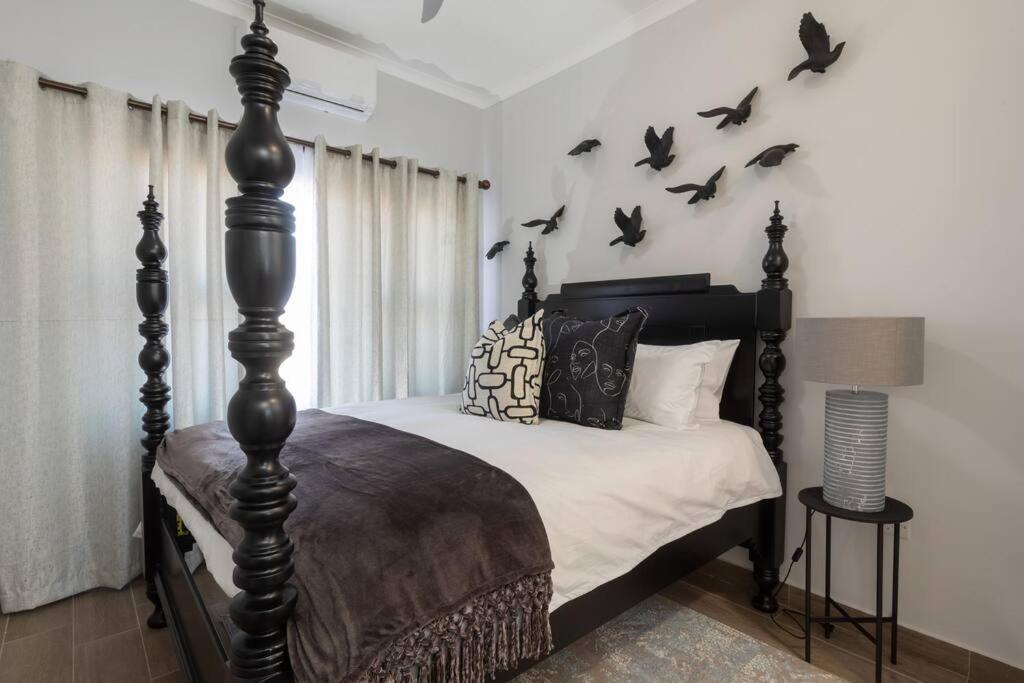 a bedroom with a bed with bats on the wall at One More Night Apartment E203 in Gaborone