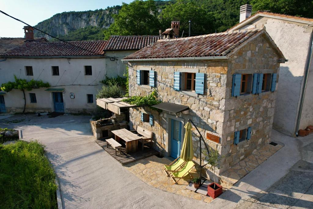an old stone building with a picnic table in front of it at Mountain Lodge Istria, Tiny house in Roč