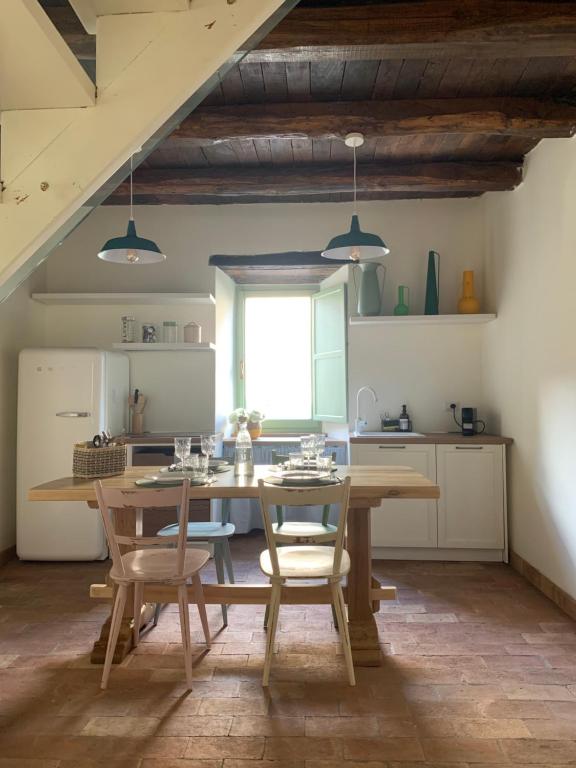 a kitchen with a wooden table and chairs in a room at Civita Secret Lodge in Lubriano