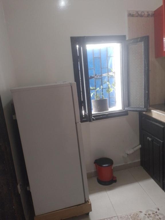 uma cozinha com um frigorífico e uma janela em منزل الضيافة em Rabat
