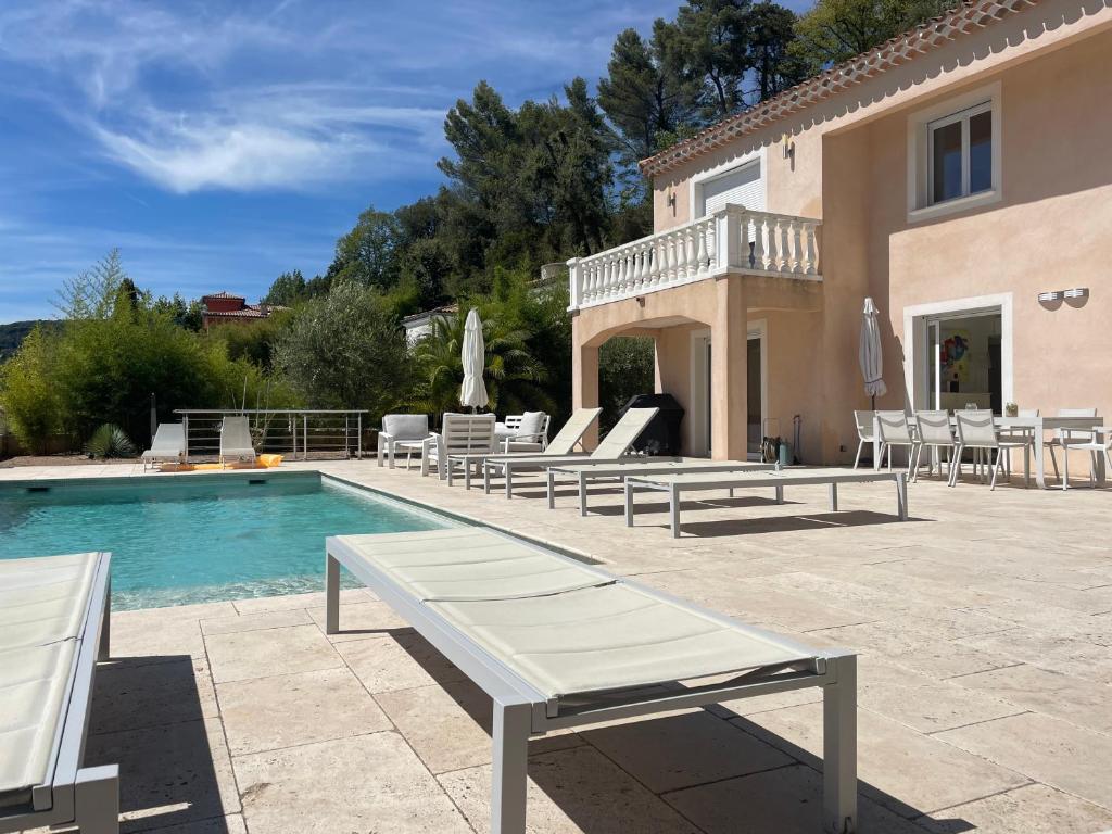 una villa con piscina, tavoli e sedie di Villa Violaine a Grasse