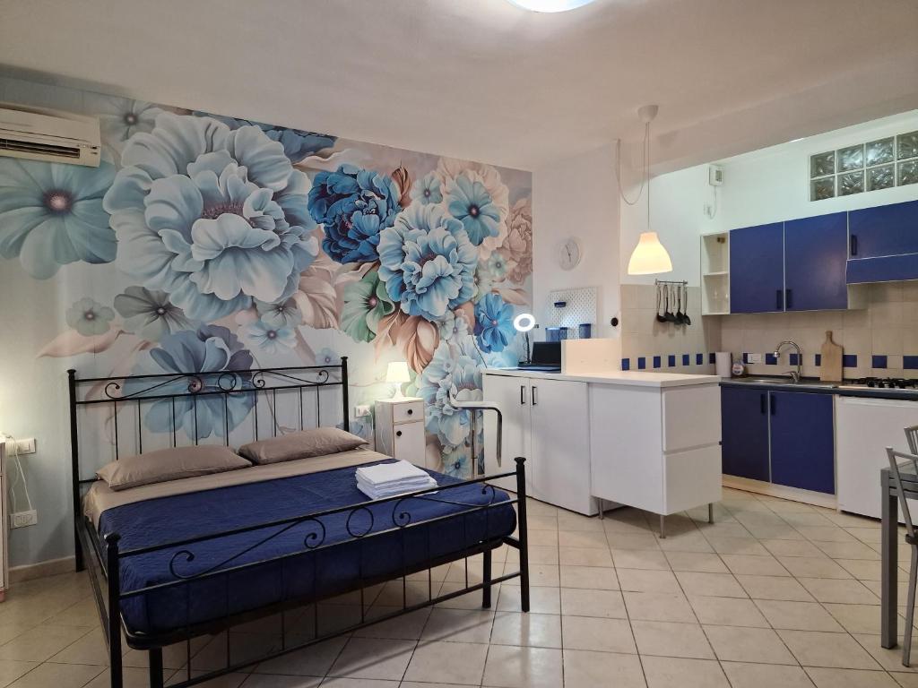 een slaapkamer met een bed met een muurschildering van bloemen aan de muur bij Casa Mon Amour Livorno in Livorno
