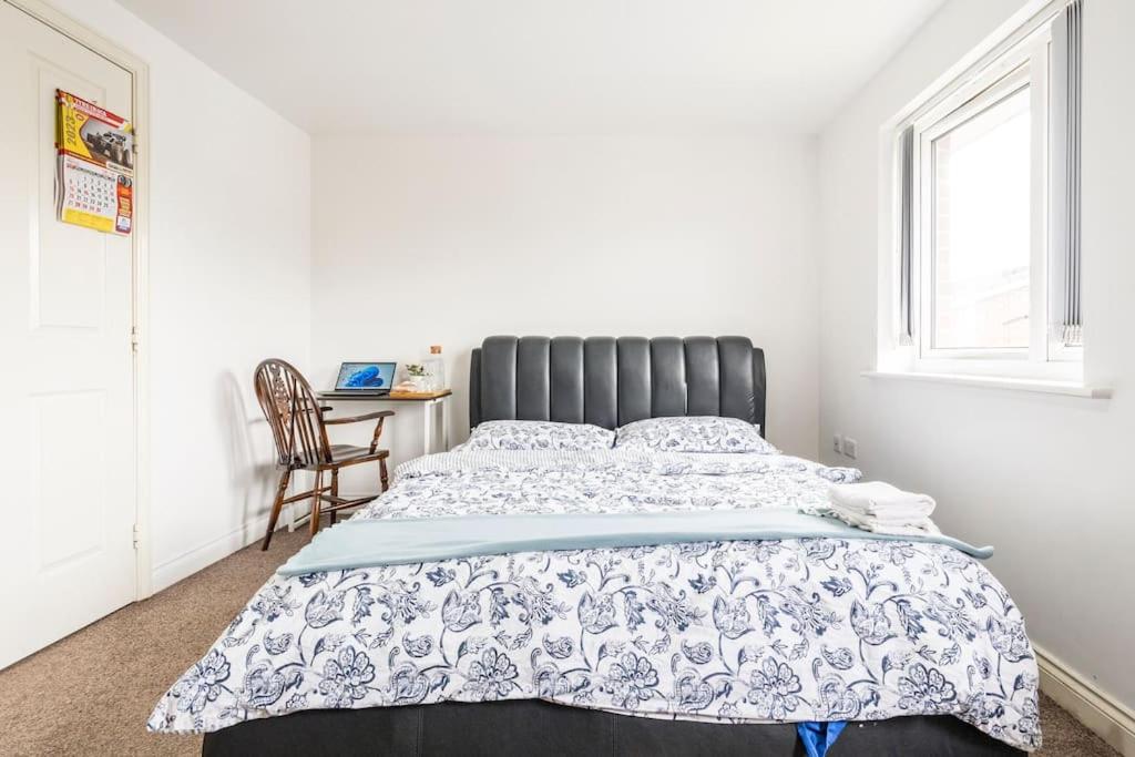 1 dormitorio con 1 cama grande y 1 silla en En-suit room with free dedicated parking en Mánchester