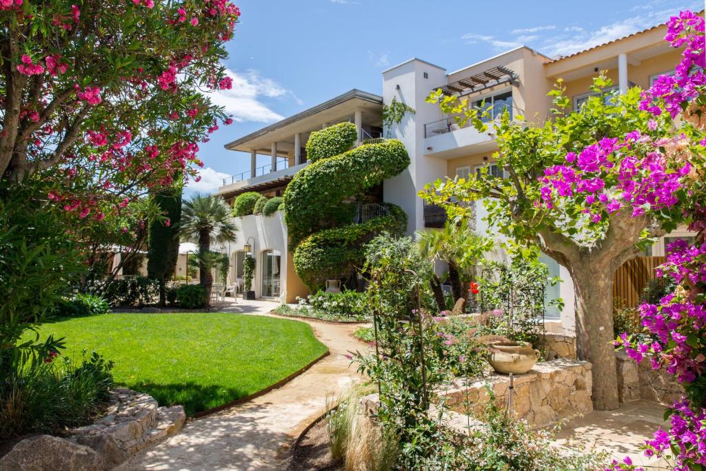 a house with a garden with pink flowers at Hôtel La Caravelle in Calvi