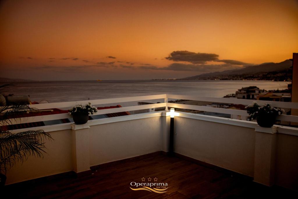 een balkon met uitzicht op de oceaan bij zonsondergang bij OPERAPRIMASUITE in Messina