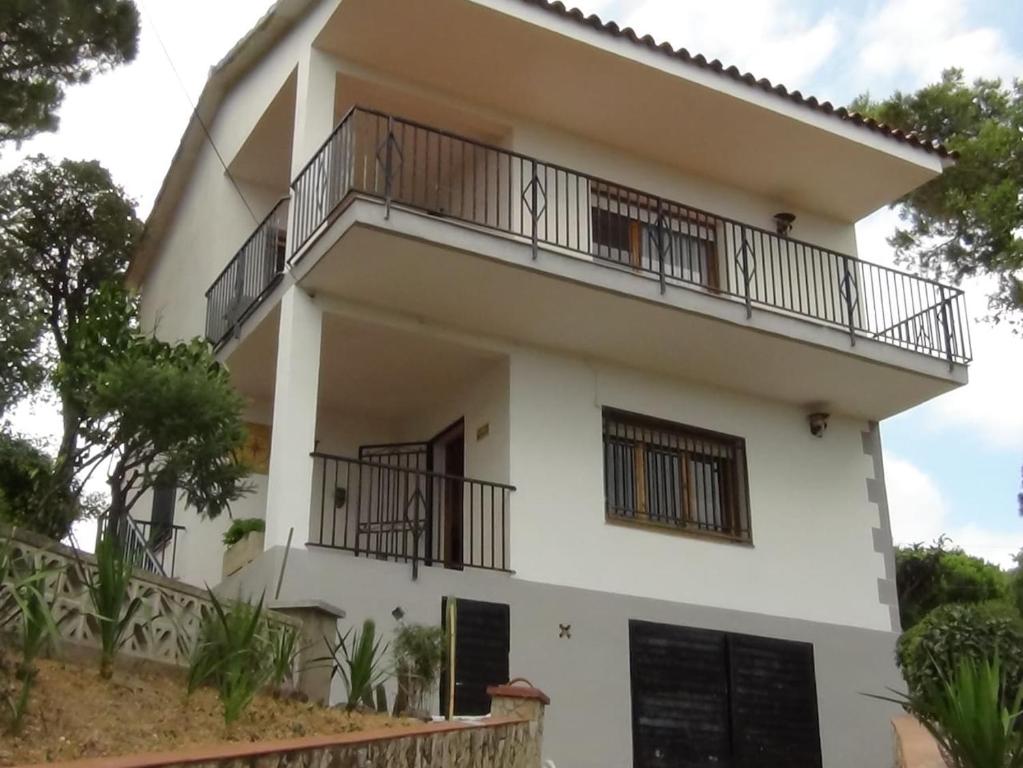 een wit huis met balkons en bomen bij Costa Brava Home in Terra Brava