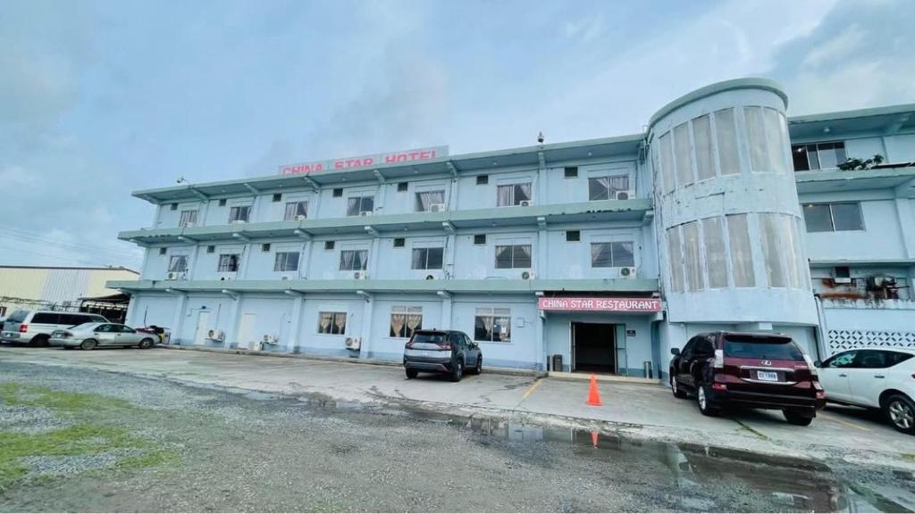 un gran edificio con coches estacionados frente a él en CHINA STAR HOTEL en Kolonia