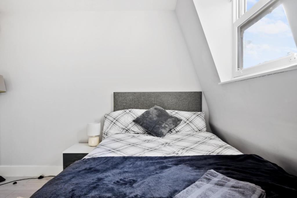 a small bedroom with a bed with a window at Private Spacious En-suite room in London