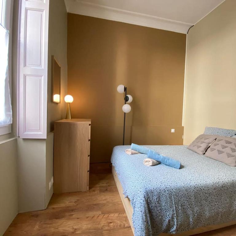 ein Schlafzimmer mit einem Bett mit einer blauen Decke in der Unterkunft NIMES FOULC in Nîmes
