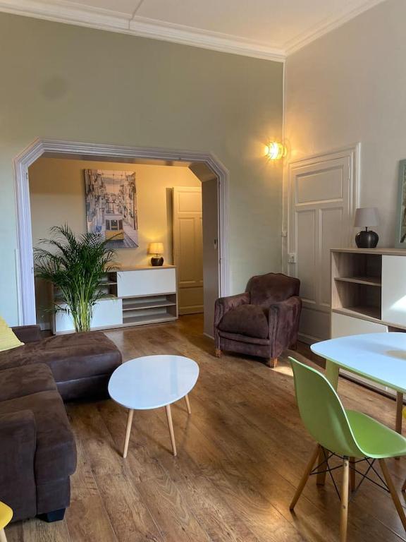 ein Wohnzimmer mit einem Sofa und einem Tisch in der Unterkunft NIMES FOULC in Nîmes