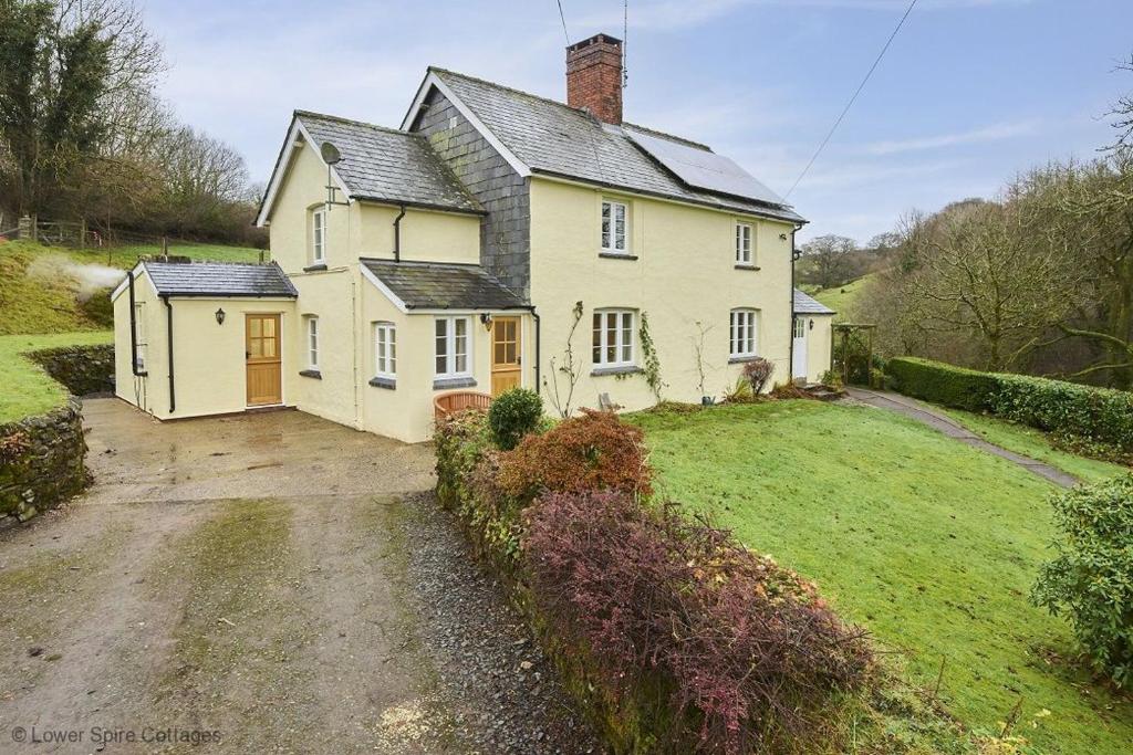 una grande casa bianca con un prato di 1 Lower Spire a Dulverton