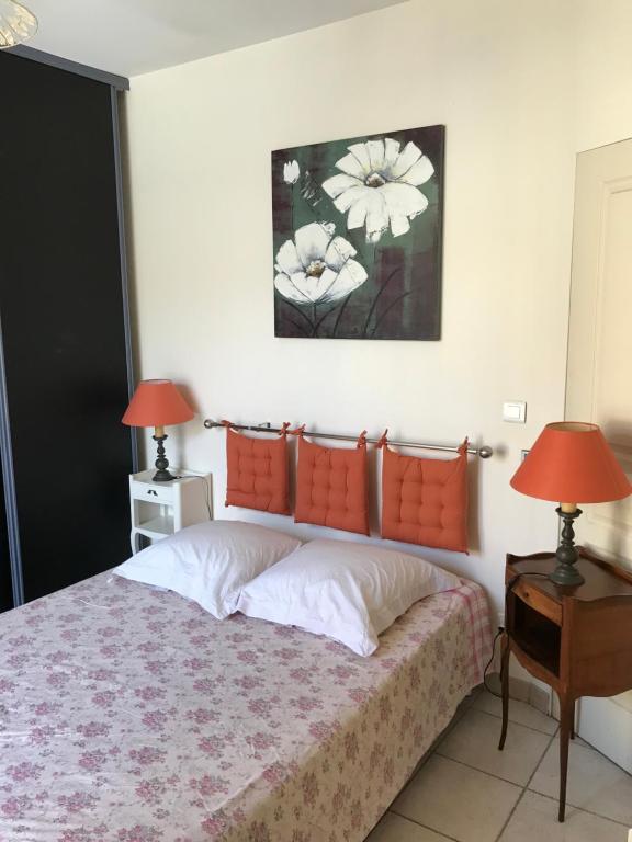 モンペリエにあるChambre Abri Urbainのベッドルーム1室(オレンジ色の枕とランプ2つ付)