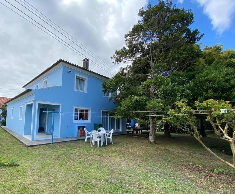 a blue house with a picnic table in the yard at Quinta das rãs in Ponta Delgada
