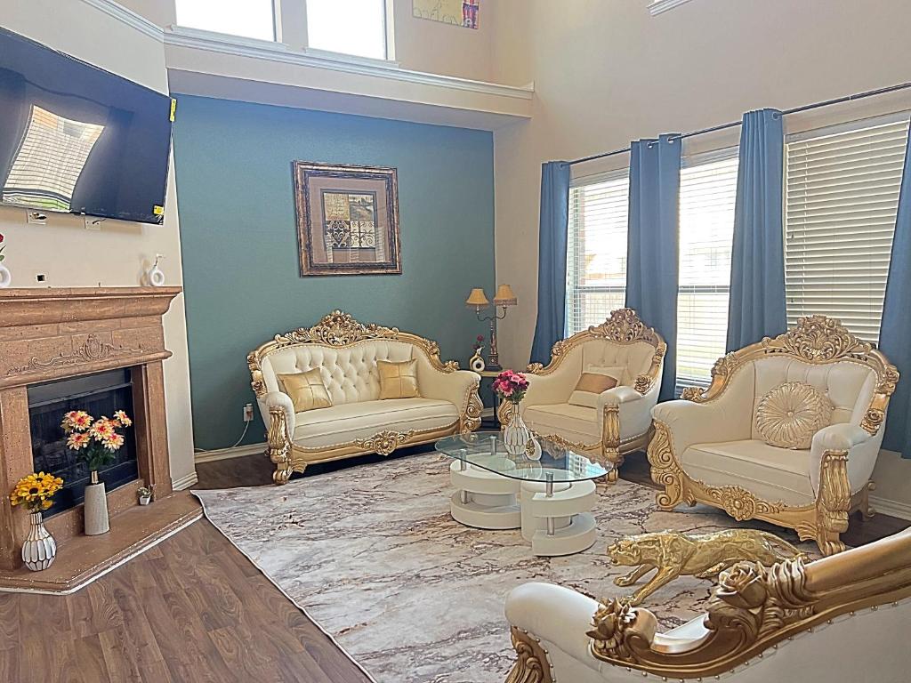 a living room with white furniture and a fireplace at The Queens luxury palace in Grand Prairie