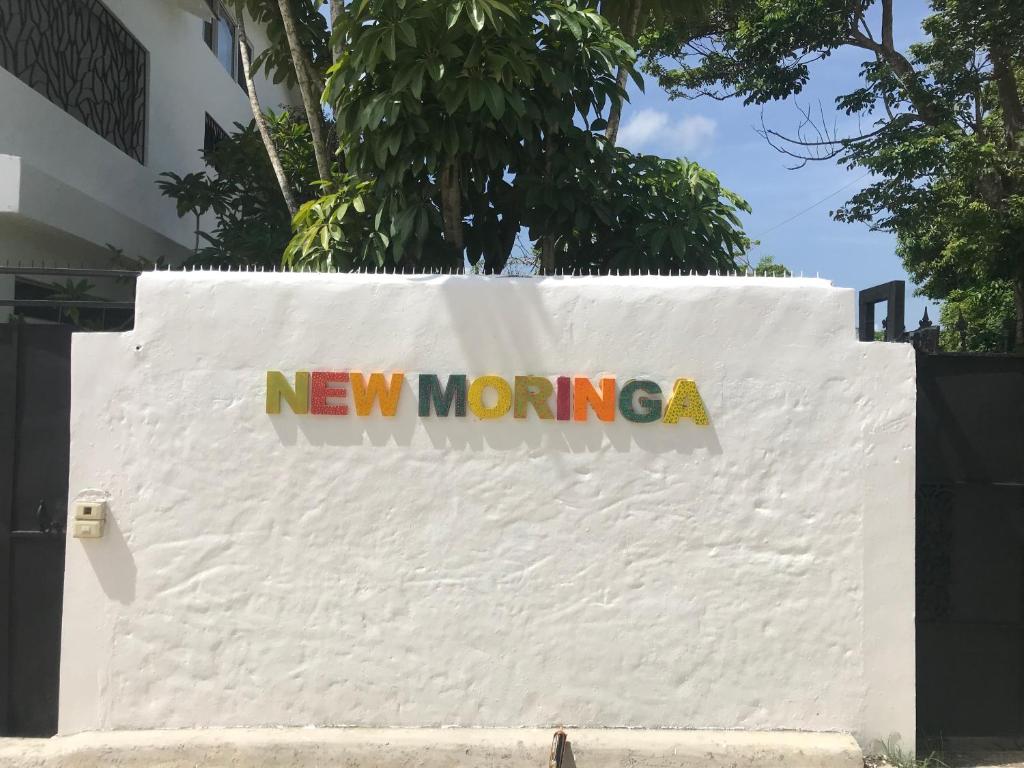 a new moring sign on a white wall at NEW MORINGA in Las Terrenas