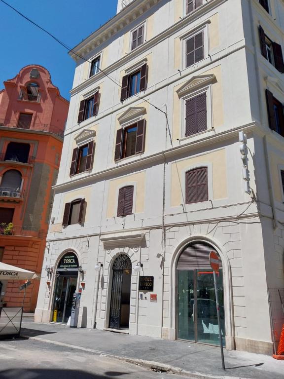 - un grand bâtiment blanc dans une rue de la ville dans l'établissement Hotel Lirico, à Rome