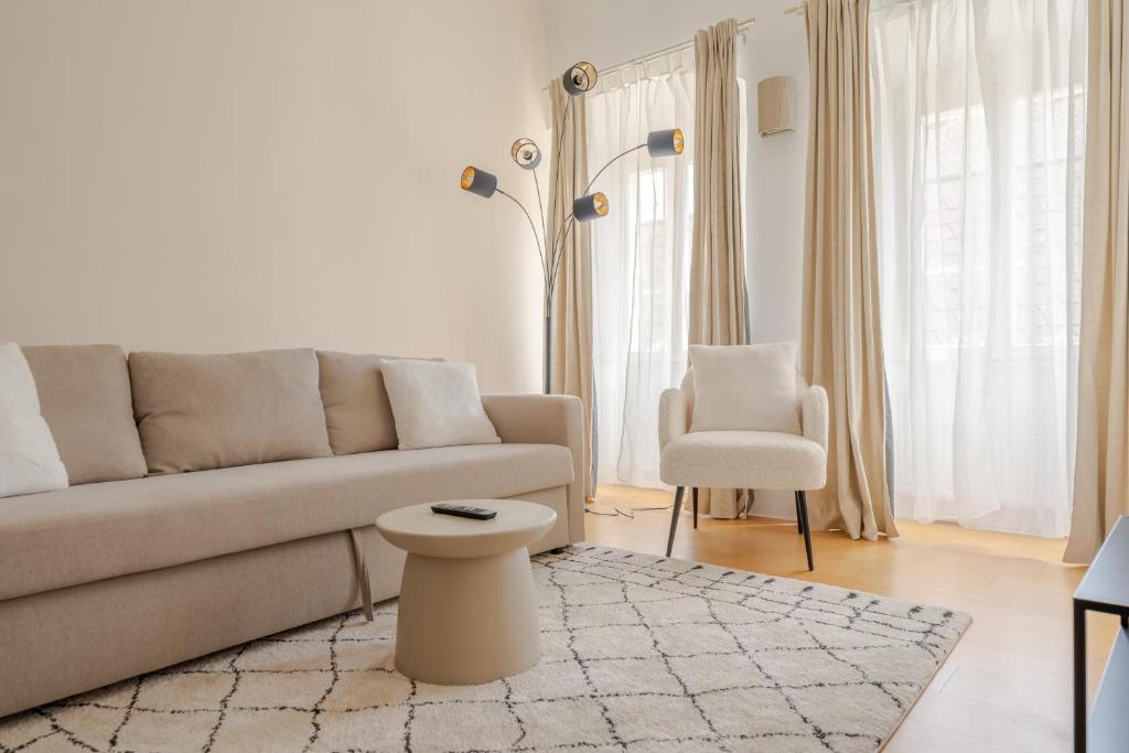 een woonkamer met een bank en een stoel bij Cozy-City Appartement in Krems an der Donau