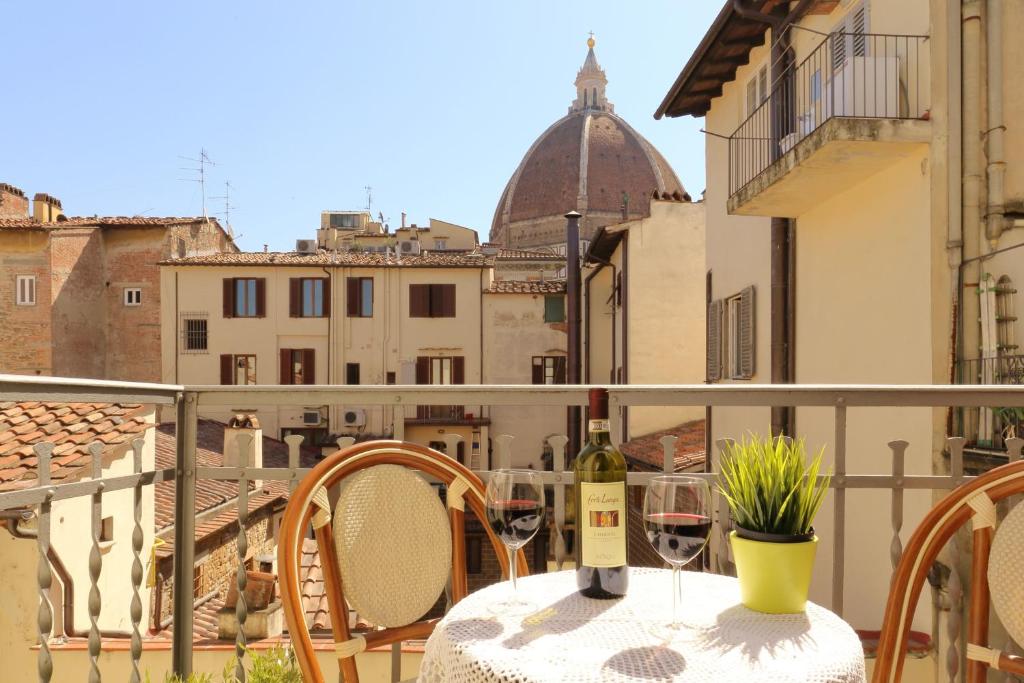 stół z dwoma kieliszkami wina na balkonie w obiekcie Guesthouse Bel Duomo we Florencji