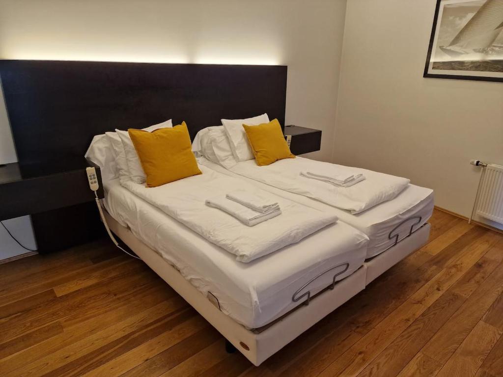1 cama grande con sábanas blancas y almohadas amarillas en Alfred's Premium Vatnsstígur, en Reikiavik