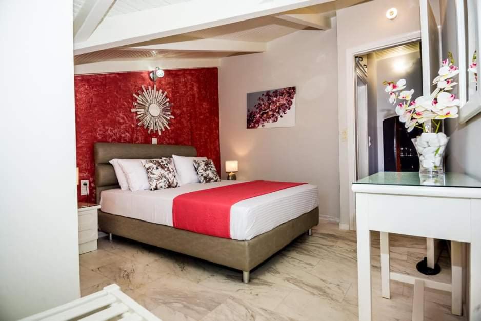 ein Schlafzimmer mit einem Bett mit einer roten Wand in der Unterkunft Rena’s house 2 in Argostoli