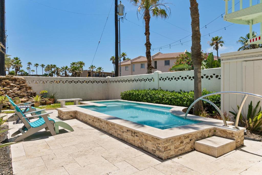 uma piscina com um banco e uma cadeira num quintal em 3-level townhome w/ private pool & close to beach! em South Padre Island