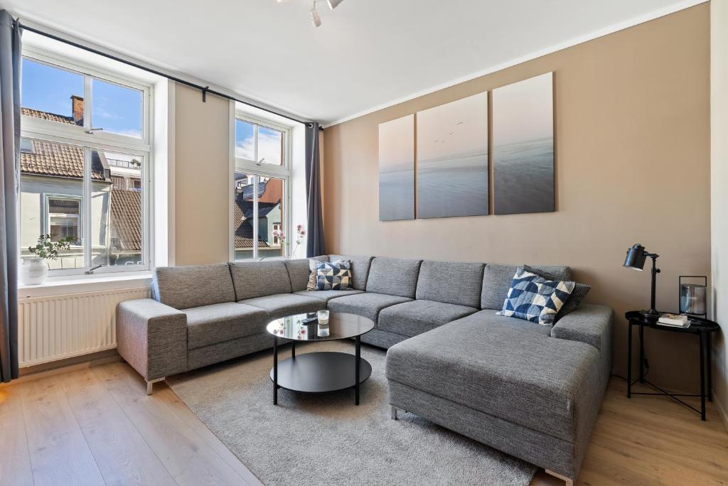 uma sala de estar com um sofá e uma mesa em Ny sentral og moderne leilighet em Kristiansand