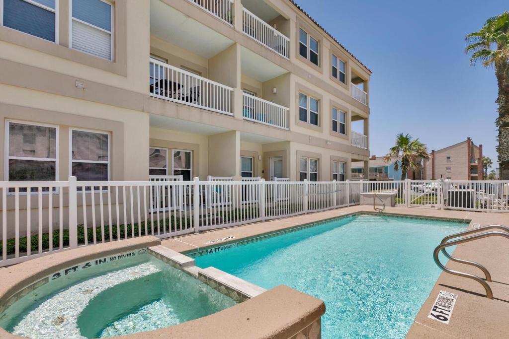 a swimming pool in front of a apartment building at Ground floor condo steps from pool, next to beach! in South Padre Island