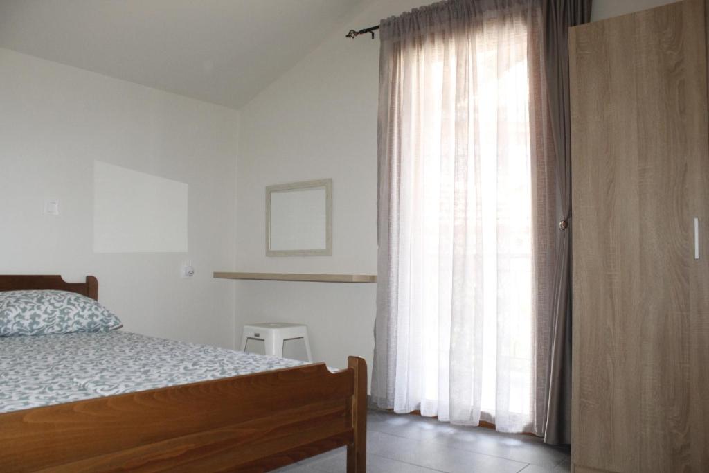 a bedroom with a bed and a large window at Zeusplace Anastasia's Apartment 2 in Litochoro