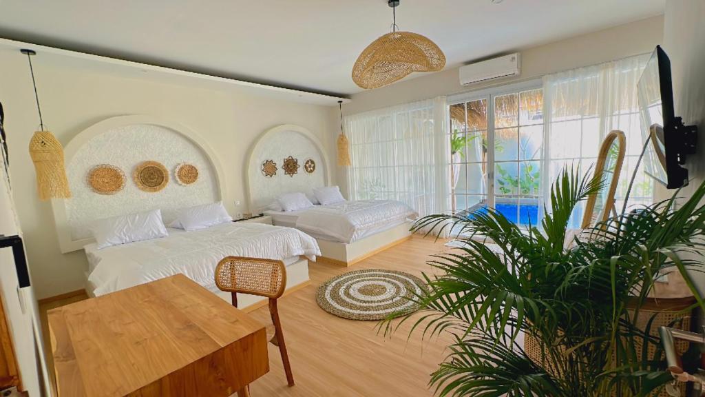 Kejayan的住宿－Demoska Villa Jogja With Privatepool，一间卧室设有两张床和盆栽植物