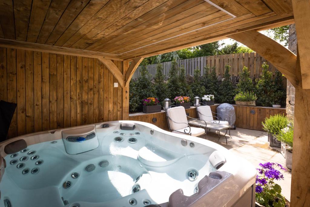 une baignoire jacuzzi au milieu d'un patio dans l'établissement Cotswold cottage with hot tub, à Bledington