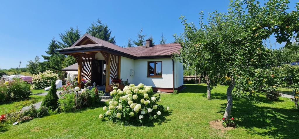 une petite maison dans une cour avec un arbre dans l'établissement Domek na wsi, à Jedle