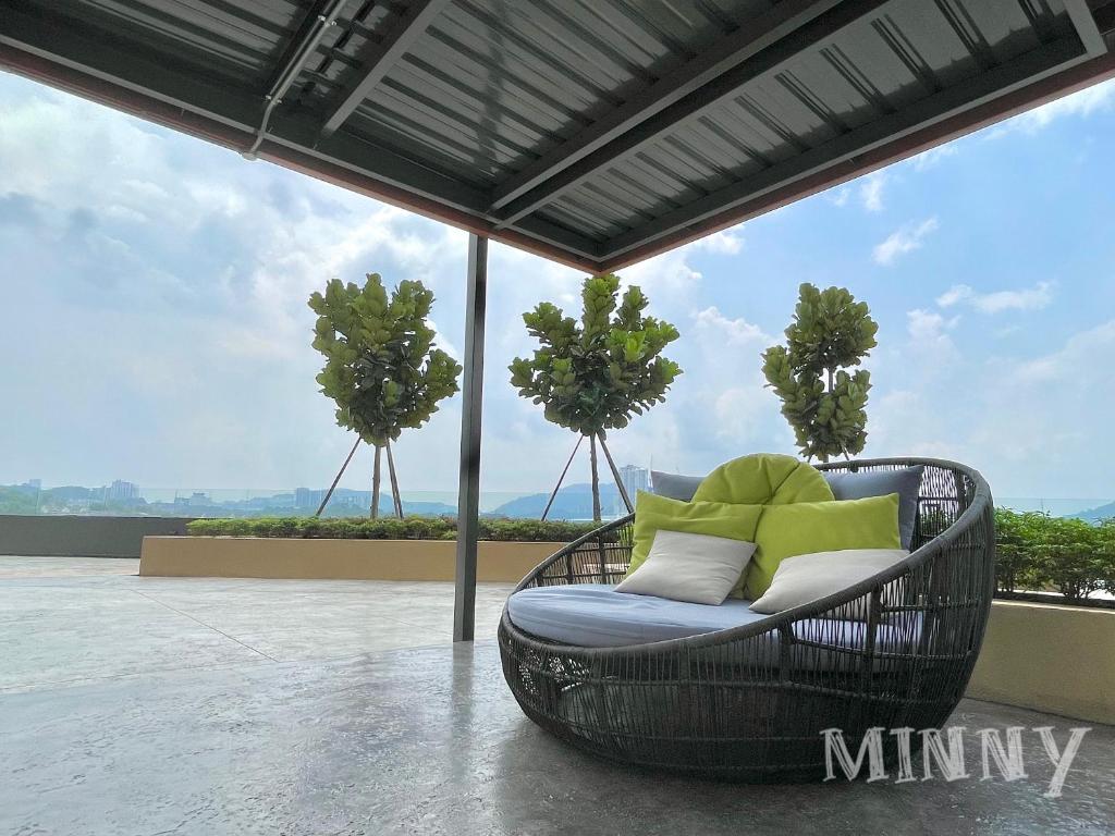 einen Korbstuhl auf einer Terrasse mit Bäumen im Hintergrund in der Unterkunft Netizen near MRT Balcony View in Cheras