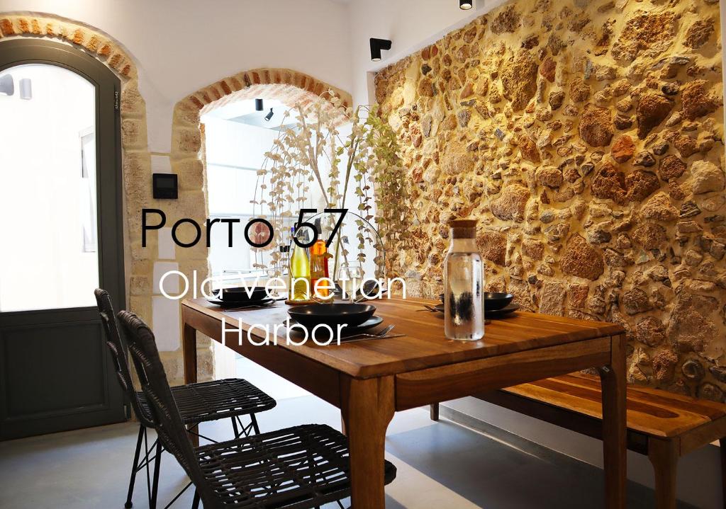 un tavolo in legno in una stanza con un muro in pietra di Porto 57 a Chania