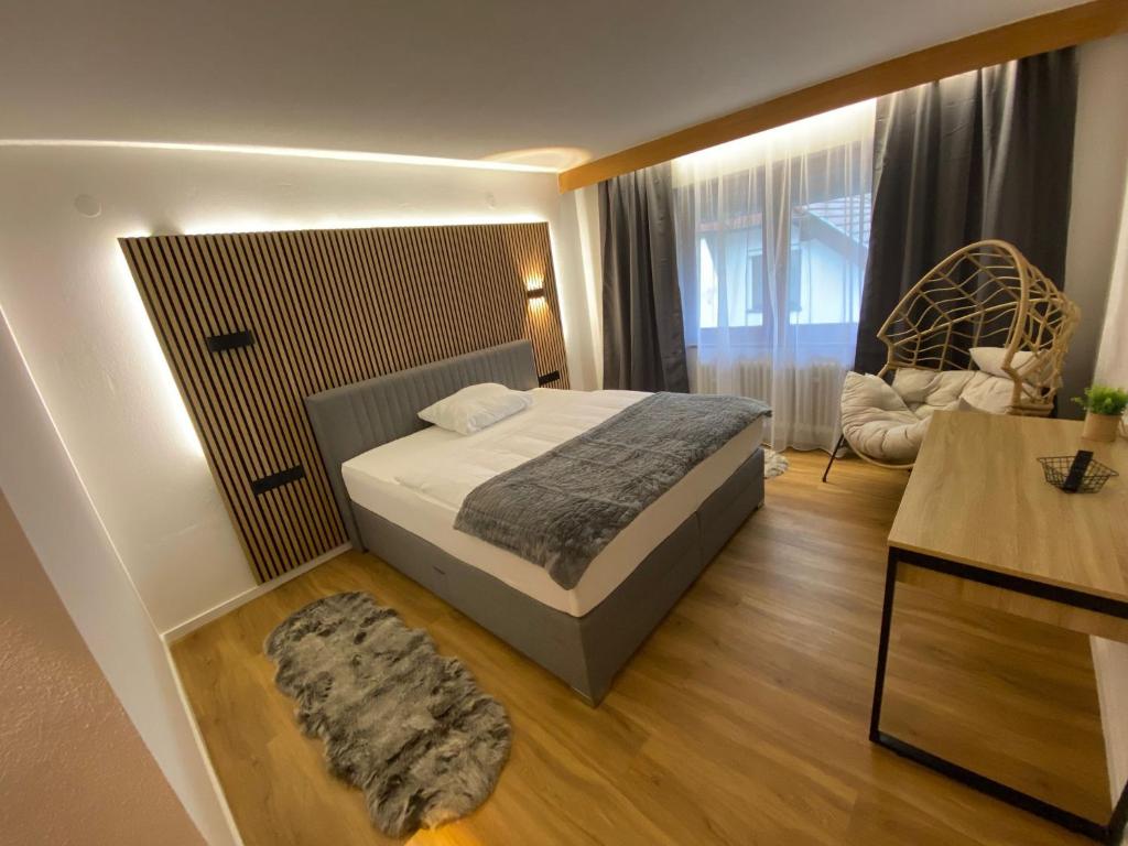 a bedroom with a bed and a chair in a room at Naturhotel Blaubach in Blaubach