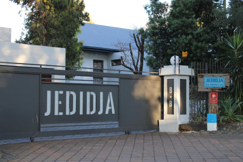 uma cerca com uma placa de Jededia em frente a uma casa em Jedidja Bed and Breakfast em Bloemfontein