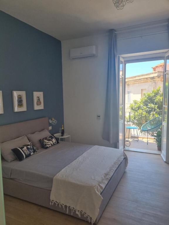 a bedroom with a bed and a sliding glass door at Sunset 221 Cagliari in Cagliari