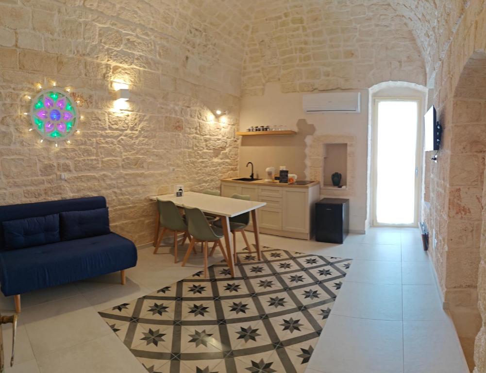 ein Wohnzimmer mit einem Tisch und einem blauen Sofa in der Unterkunft Casa Munna in Ceglie Messapica