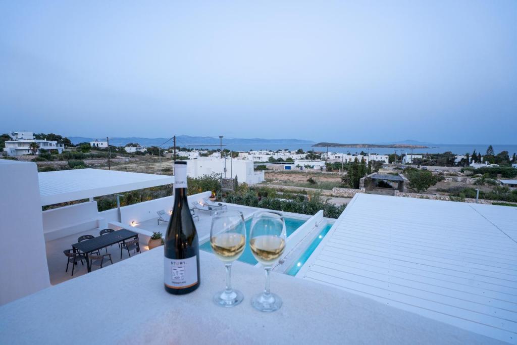 a bottle of wine and two glasses on a table at Paros Breeze Luxury Villa in Drios