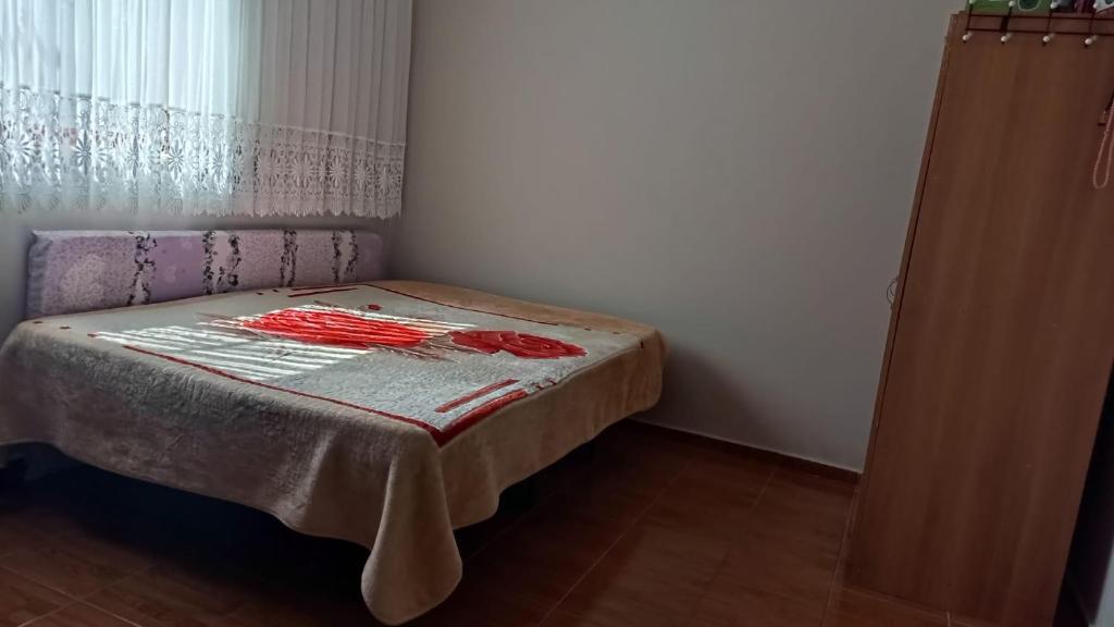 a small bedroom with a bed with a blanket on it at AYTEN'NİN KIR EVİ in Trabzon