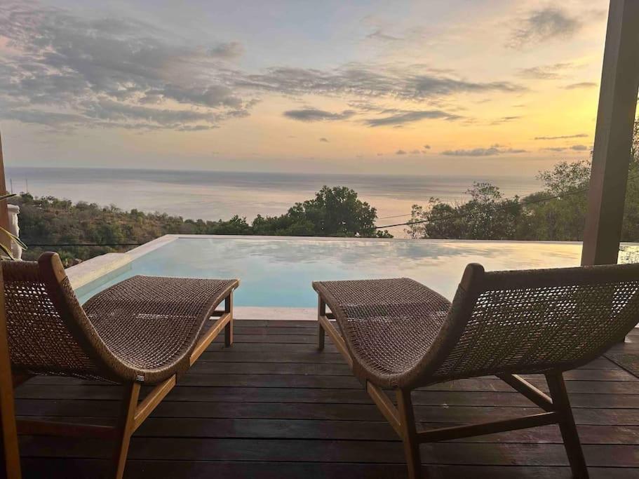 Ambat的住宿－Hillside Chalet with panoramic views，一个带两把椅子的甲板和一个游泳池