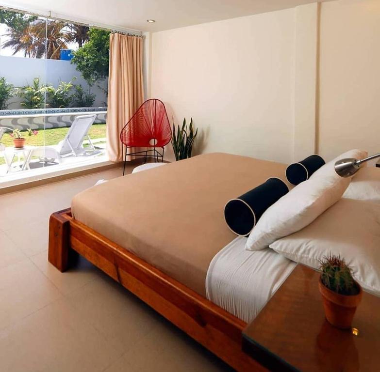 a bedroom with a large bed and a window at Posada Buena Vista Beach Club in El Yaque