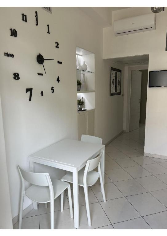 a white table and chairs and a clock on a wall at Lingotto35 in Turin