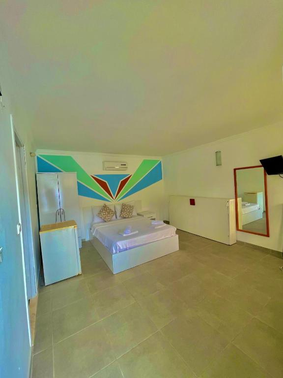 a large bedroom with a bed and a mirror at Korsanada Hotel in Kaş