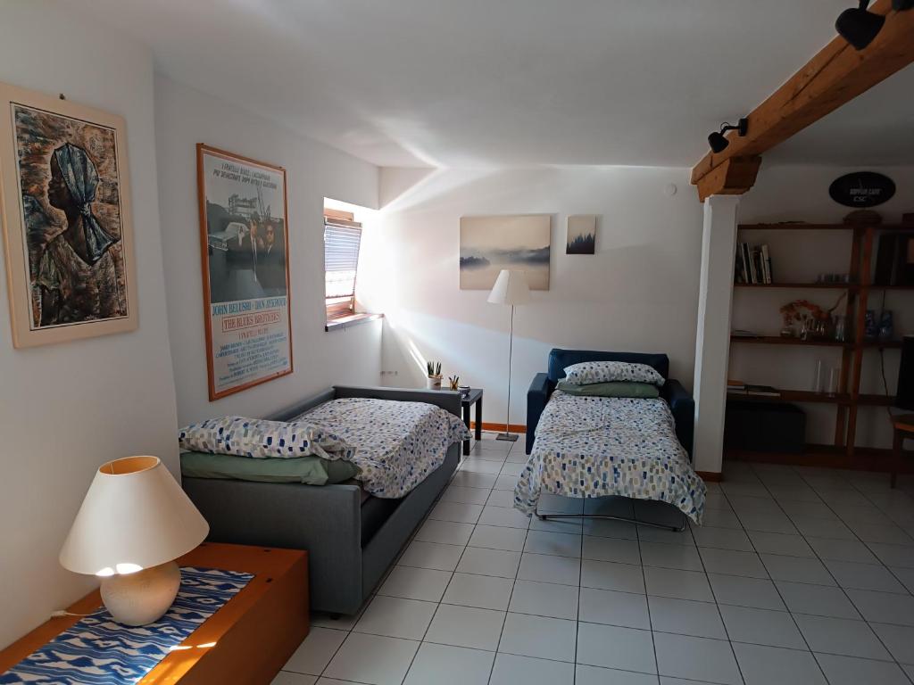 uma sala de estar com duas camas e um sofá em Amnis em Aquileia