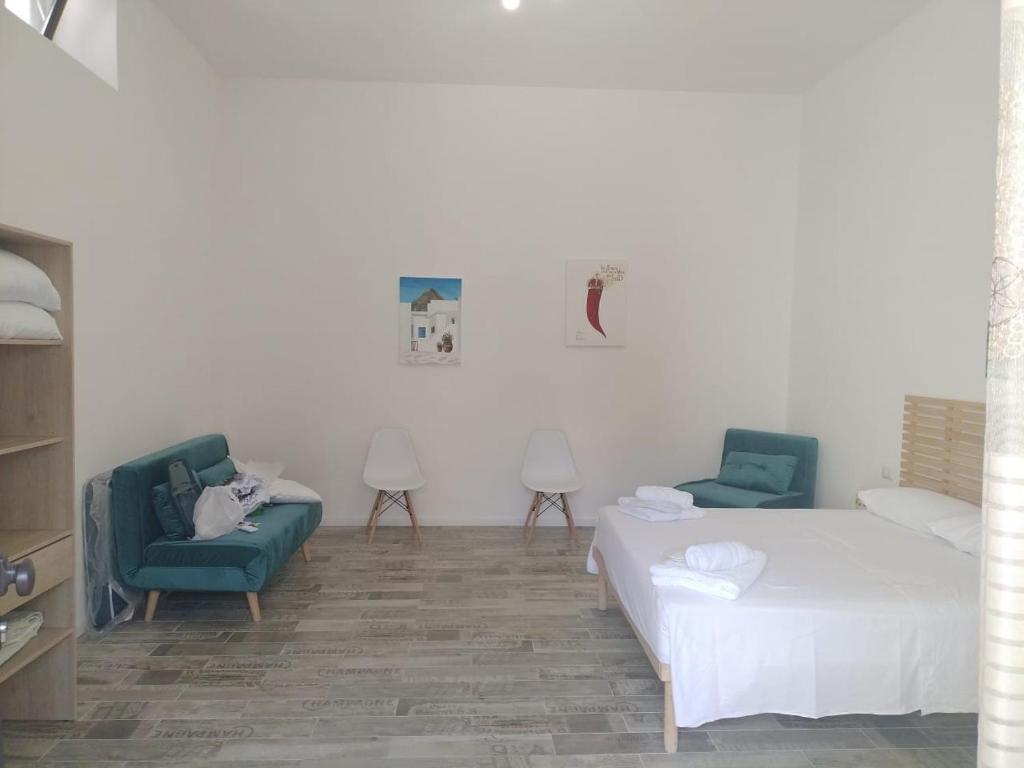 a bedroom with two beds and two chairs and a cat laying on a couch at Il Regno delle due Sicilie in Riposto